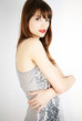 portrait of a woman posing on white background in a silver dress