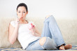 Foto: Frau mit Eisbecher auf der Couch Frau mit Eisbecher auf der Couch