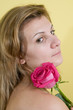 Foto: Beautiful young girl with pink rose on yellow background Beautiful young girl with pink rose on yellow background