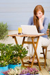 Summer terrace redhead woman with laptop Summer terrace redhead woman with laptop