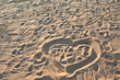 heart on the beach sand, footprints