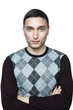 Young man in black checkered sweater with crossed arms