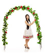 Ñute girl near the arch entwined by roses