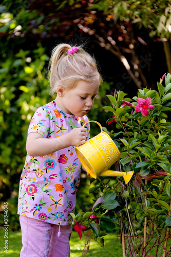 Photo: Kind mit Gießkanne beim Blumen giessen Kind mit Gießkanne beim Blumen giessen