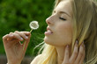 Junge Frau mit einer Pusteblume