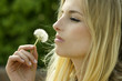 Junge Frau mit einer Pusteblume