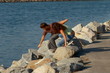 Young couple climbing rocks by water