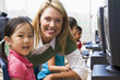 Teacher helping kindergarten children learn how to use computers