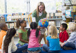 Foto: Kindergarten teacher and children looking at globe in library Kindergarten teacher and children looking at globe in library