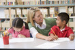 Kindergarten teacher helping students with writing skills