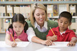 Kindergarten teacher helping students with writing skills
