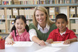 Kindergarten teacher helping students learn writing skills