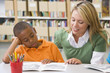 Kindergarten teacher helping student with reading skills