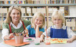 Kindergarten teacher sitting with students in art class
