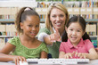 Kindergarten teacher sitting with children at computer