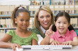 Kindergarten teacher sitting with children at computer