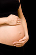 hands holding pregnant tummy isolated on black