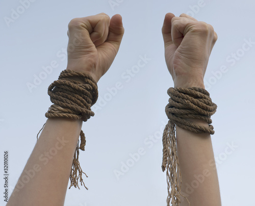Photo: Tied hands with broken rope Tied hands with broken rope