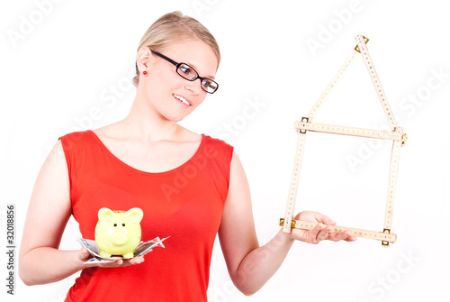 Photo: junge Frau mit Haussymbol und Sparschwein junge Frau mit Haussymbol und Sparschwein