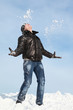 Man stands on snow throwing him  hands and looks in sky