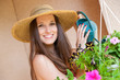 belle femme souriante qui arrose les fleurs du jardin