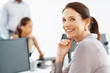 Business woman smiling with colleagues in background