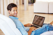 Man surfing internet on laptop and smiling