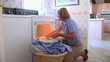 Mature woman removing clothes from dryer