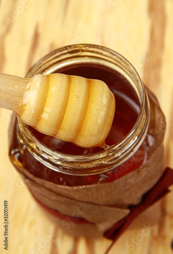 Photo: jar with honey and wooden spoon for honey jar with honey and wooden spoon for honey