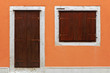 Front door and window set in orange wall in Skradin
