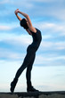 dancing woman over blue sky. Yoga