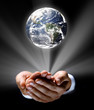 Man holding a glowing earth globe in his hands