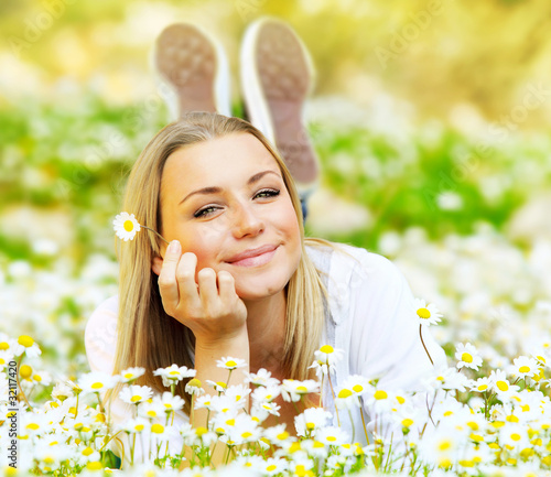 Foto: Beautiful female laying on the flower filed Beautiful female laying on the flower filed