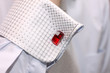 Sleeve of a white shirt with a red cuff link
