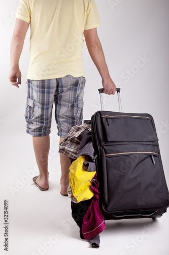 Photo: man walking with a suitcase and loosing the luggage. man walking with a suitcase and loosing the luggage.