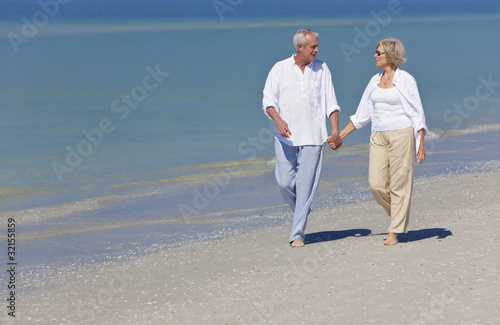 Photo: Happy Senior Couple Walking Holding Hands on Beach Happy Senior Couple Walking Holding Hands on Beach