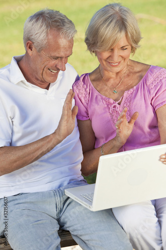 Photo: Happy Senior Couple Using Laptop Computer Outside in Sunshine Happy Senior Couple Using Laptop Computer Outside in Sunshine