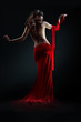 The girl in a red dress against a dark background
