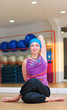 Young woman doing yoga on the floor of gym