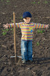 Little boy with big shovel in the field
