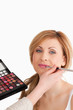 Young blond-haired woman having her make up done by a make up ar