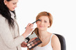 Attractive woman having her make up done by a make up artist
