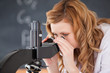Photo: Blond-haired woman looking through a microscope Blond-haired woman looking through a microscope