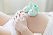 Pregnant woman holding her belly and flower