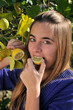Girl eating a lemon from the tree