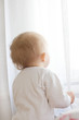 Baby girl with its back looking in window