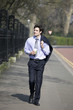 A businessman walking, holding a hot drink