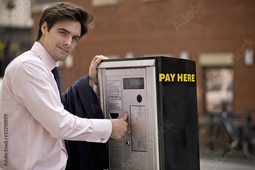 Photo: A businessman buying a ticket from a parking meter A businessman buying a ticket from a parking meter