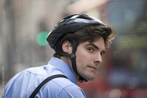 Photo: A businessman wearing a cycling helmet, commuting to work A businessman wearing a cycling helmet, commuting to work