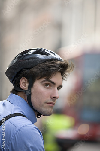 Foto: A businessman wearing a cycling helmet, commuting to work A businessman wearing a cycling helmet, commuting to work